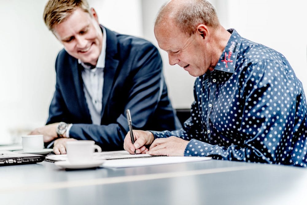 erhvervskunde underskriver forsikringsaftale
