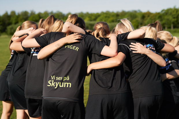 Fodboldpiger holder hinanden om skuldrene i cirkel