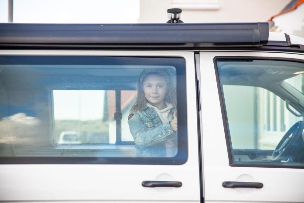 Pige lukker sidedør på campervan