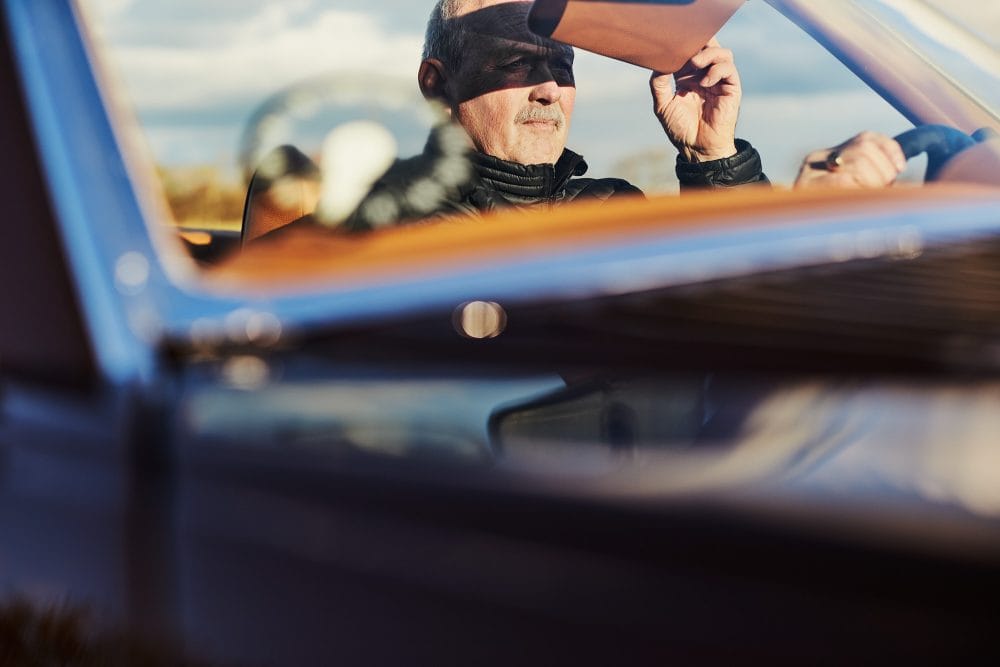 mand sidder i veteranbil