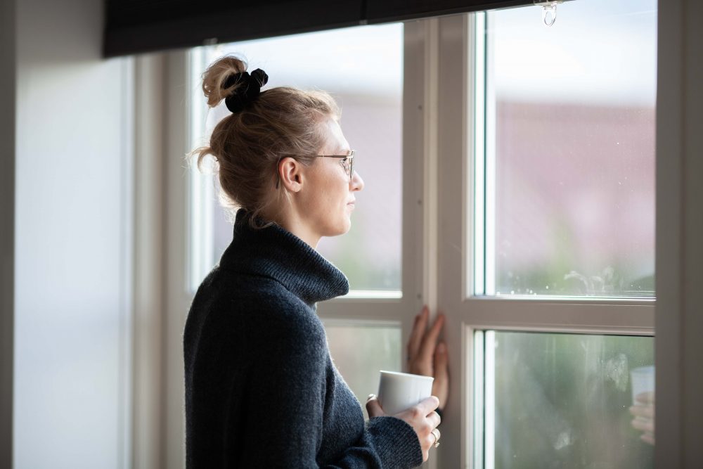 en kvinde kigger ud af et vindue