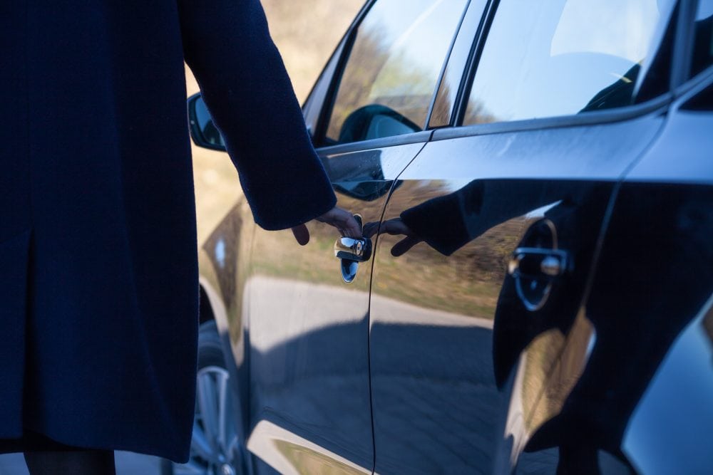 en kvinde åbner en bildør
