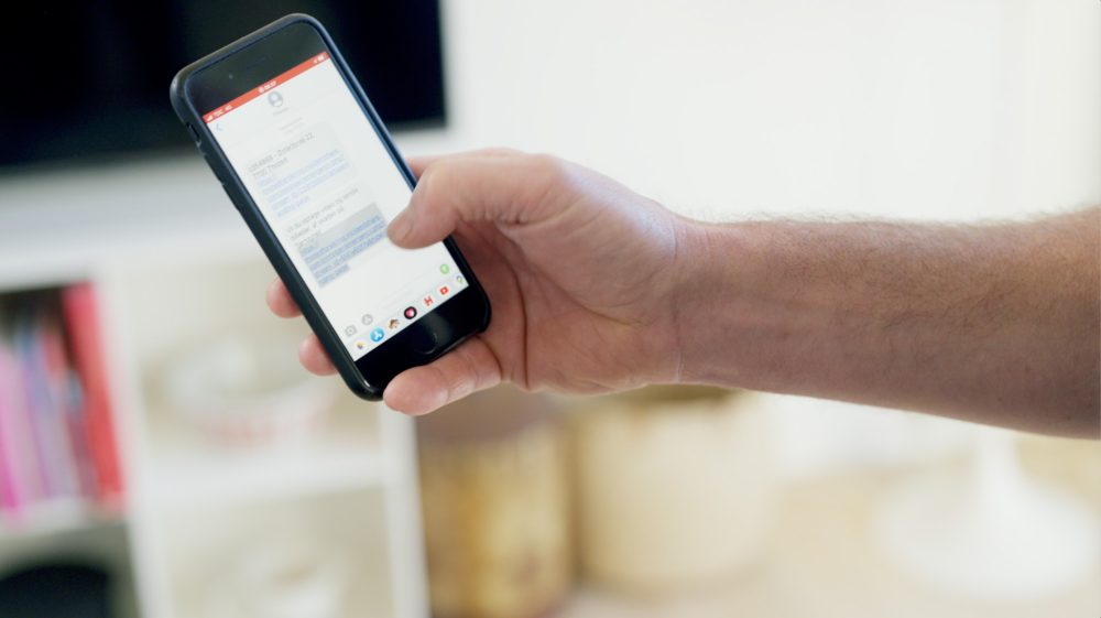 Hånd holder mobil med sms-løsning