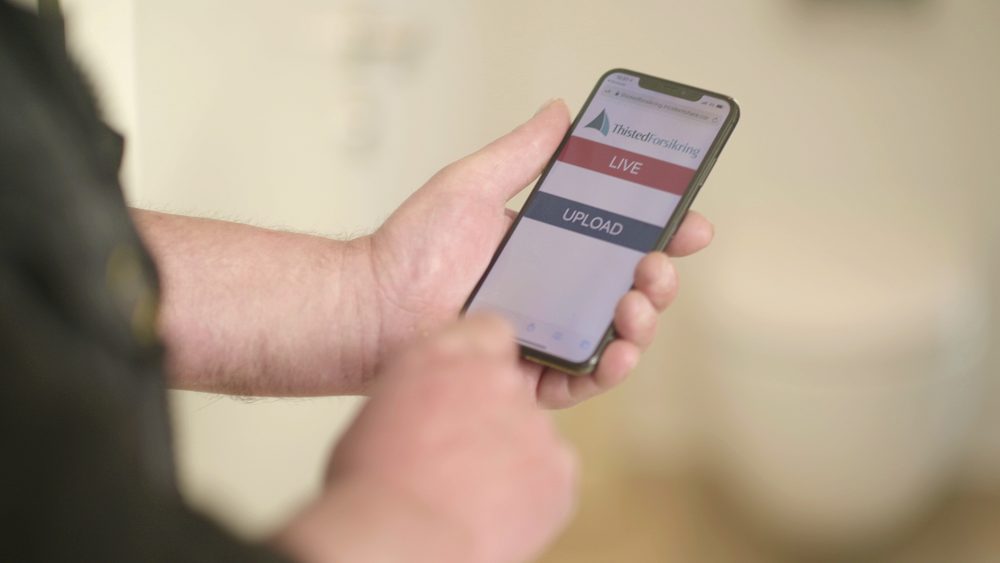 Mand holder mobiltelefon med sms-til-video