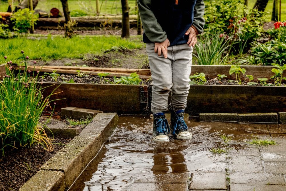 en dreng leger i en vandpyt