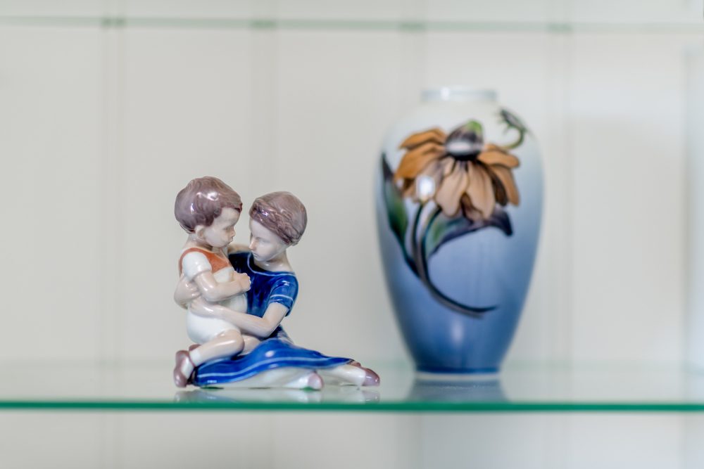 en figur og en vase står på et glasbord