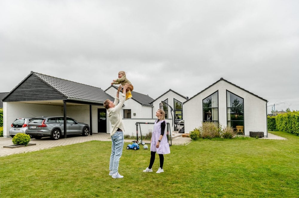 far leger med baby foran hus