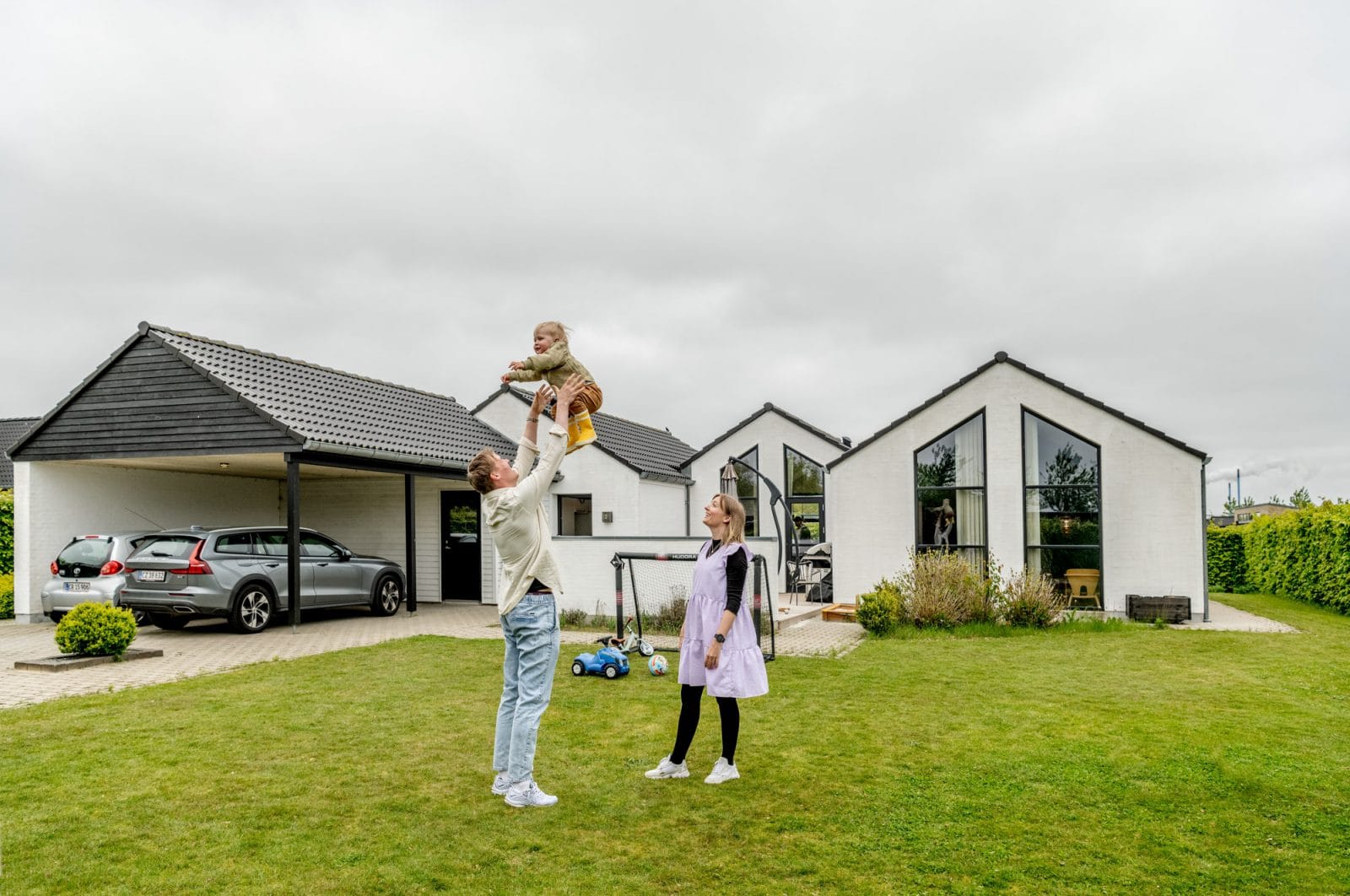 far leger med baby foran hus
