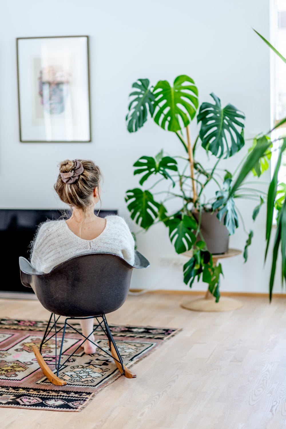 en kvinde sidder på stol og kigger ud af et vindue