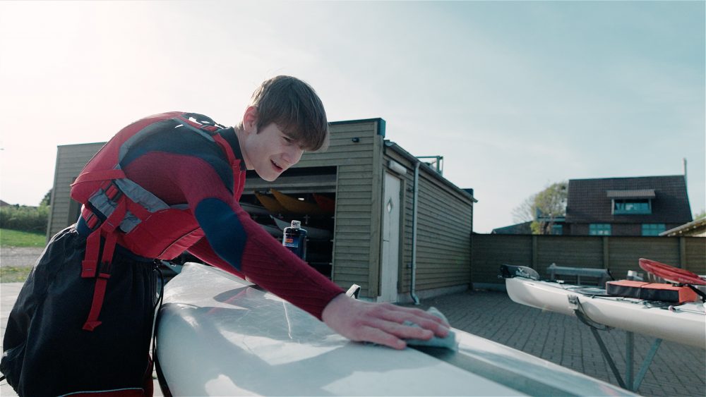 en ung mand der pudser en kajak