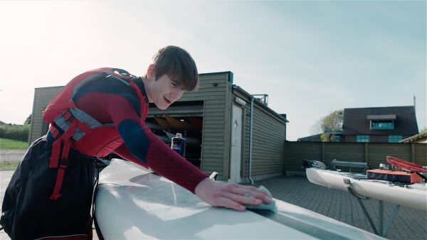 en ung mand der pudser en kajak