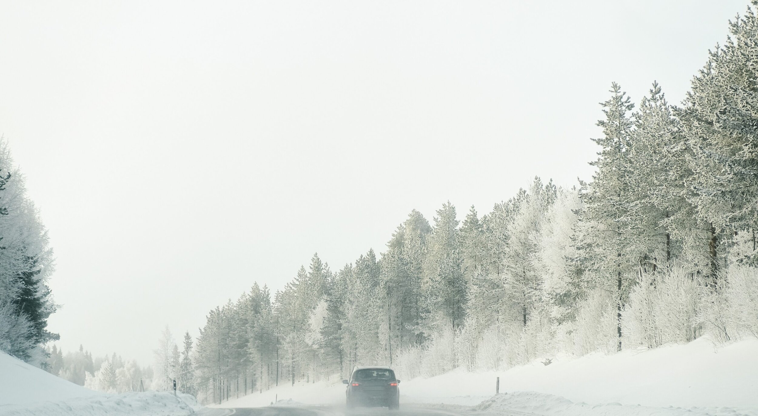 Bil på sneklædte veje om vinteren