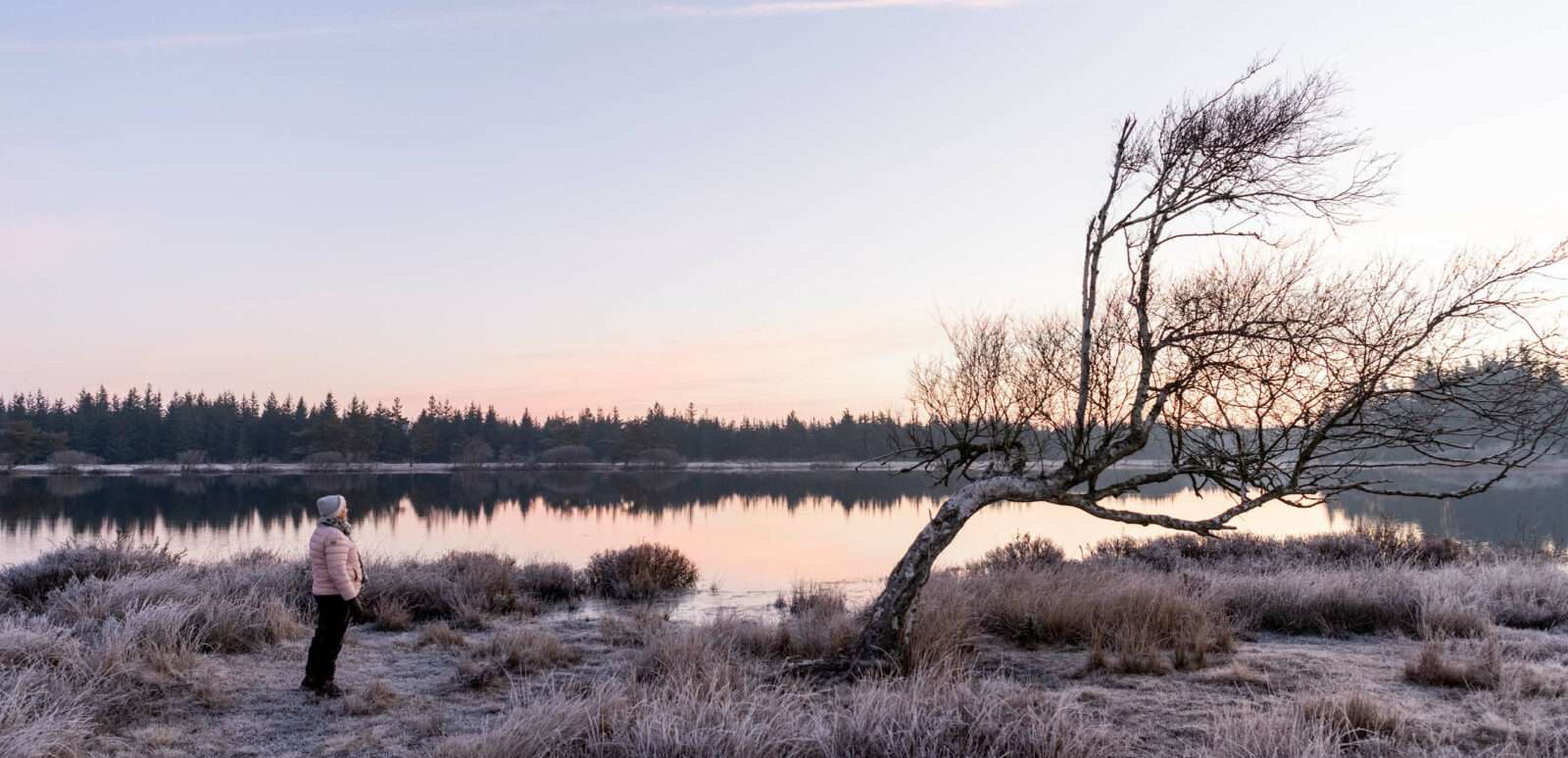 Kvinde i Tvorup Hul står ved sø og træ. Få personlig rådgivning hos Thisted Forsikring